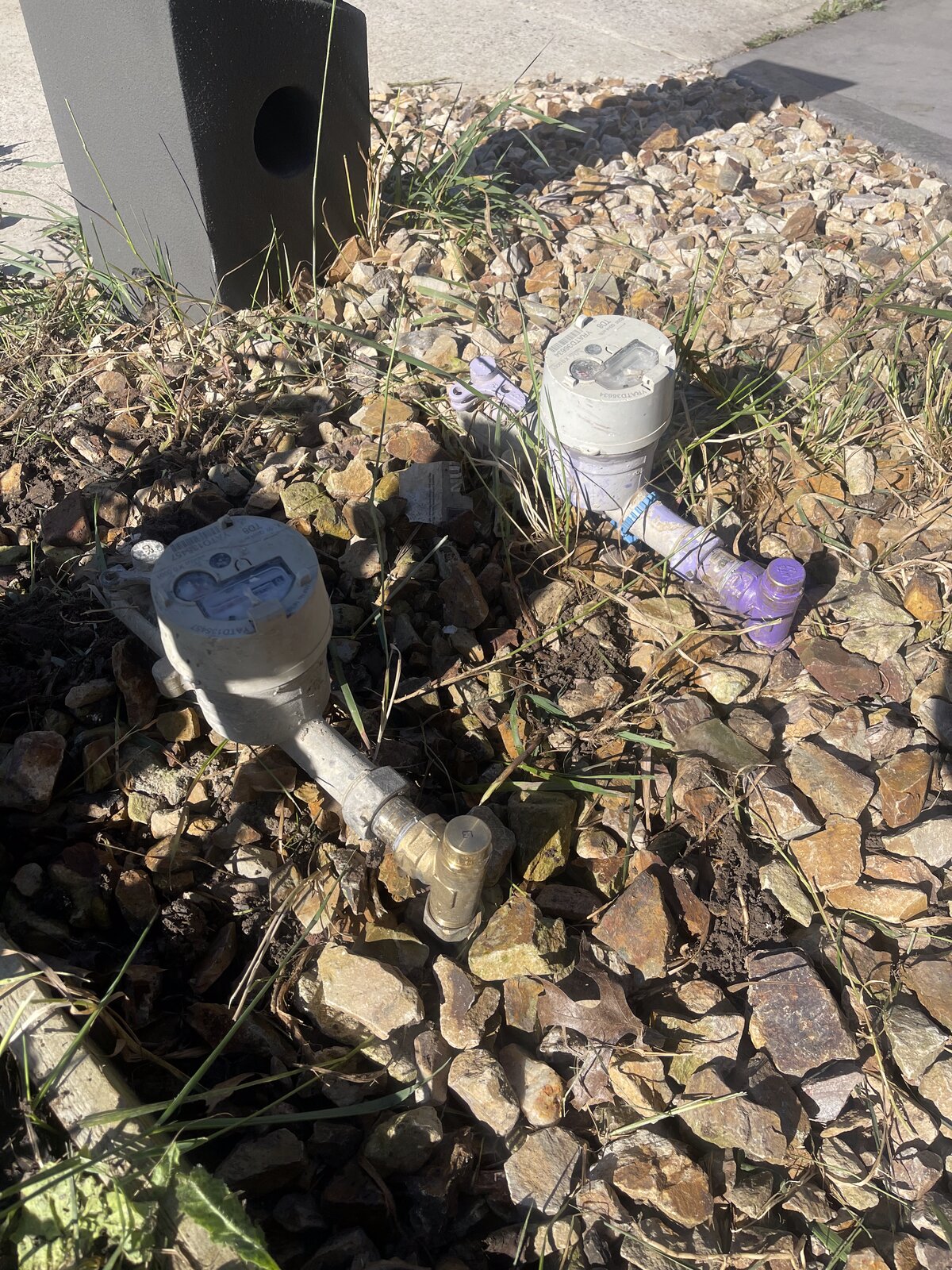 Two capped white plastic pipe ends visible in rock garden Melbourne
